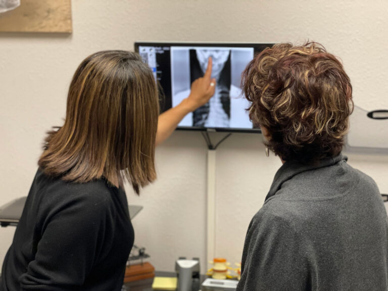 Practitioner reviewing spinal imaging with a client